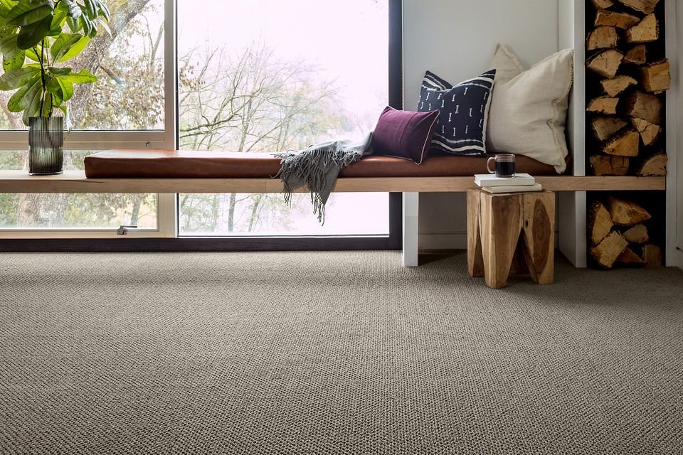 relaxing corner with a big window and gray carpet